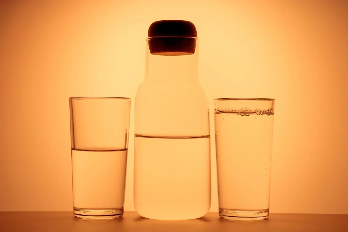 a bottle and two glasses on an orange background. a gradient from an orange background.