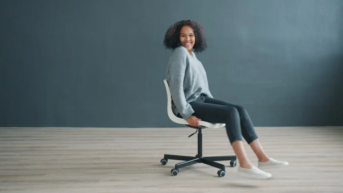 of carefree Afro-American woman spinning on chair in studio enjoying funny activity having fun alone on black background. People and lifestyle concept.