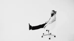 Man sitting in chair with leg extended
