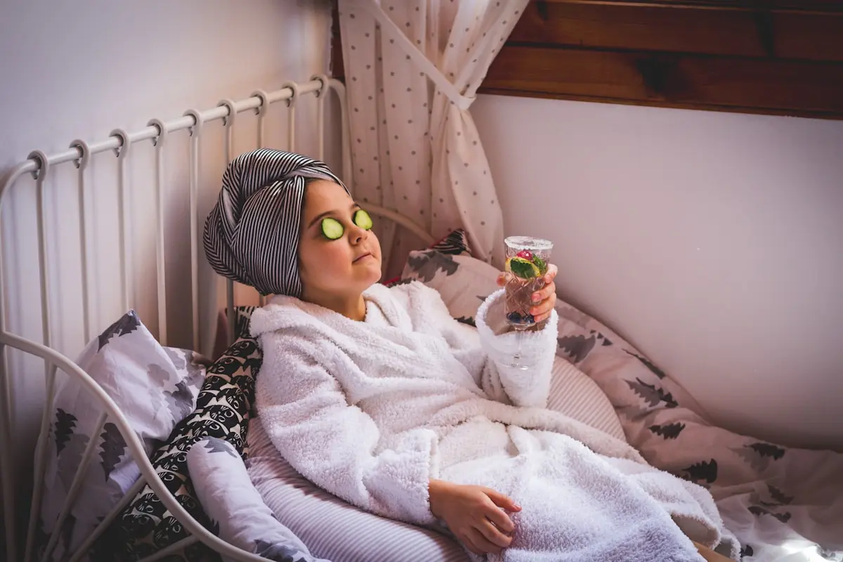 baby in white sweater and yellow goggles lying on bed