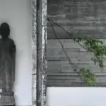 a statue of a man standing next to a building