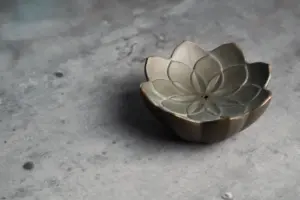 A small, ornate lotus-shaped incense holder.