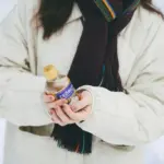 a woman holding a bottle of hot sauce in her hands