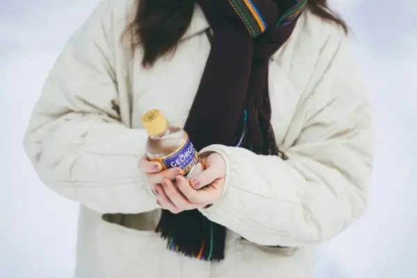 a woman holding a bottle of hot sauce in her hands